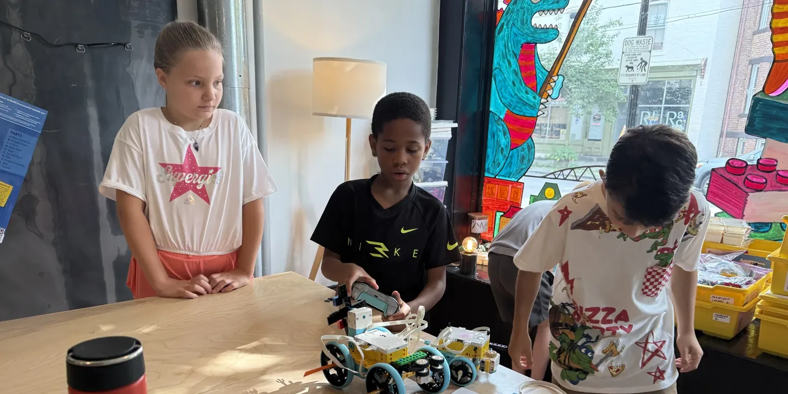 Three students testing a LEGO rover they built