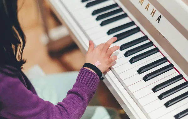 A child playing a white piano