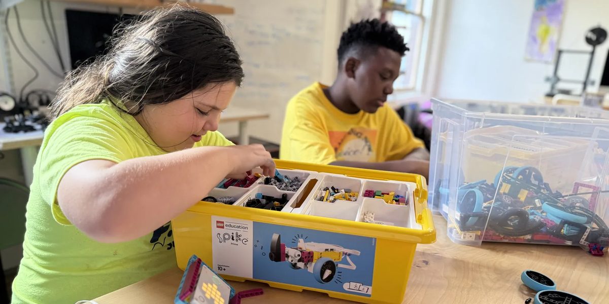 Students sorting LEGO SPIKE parts to build robots