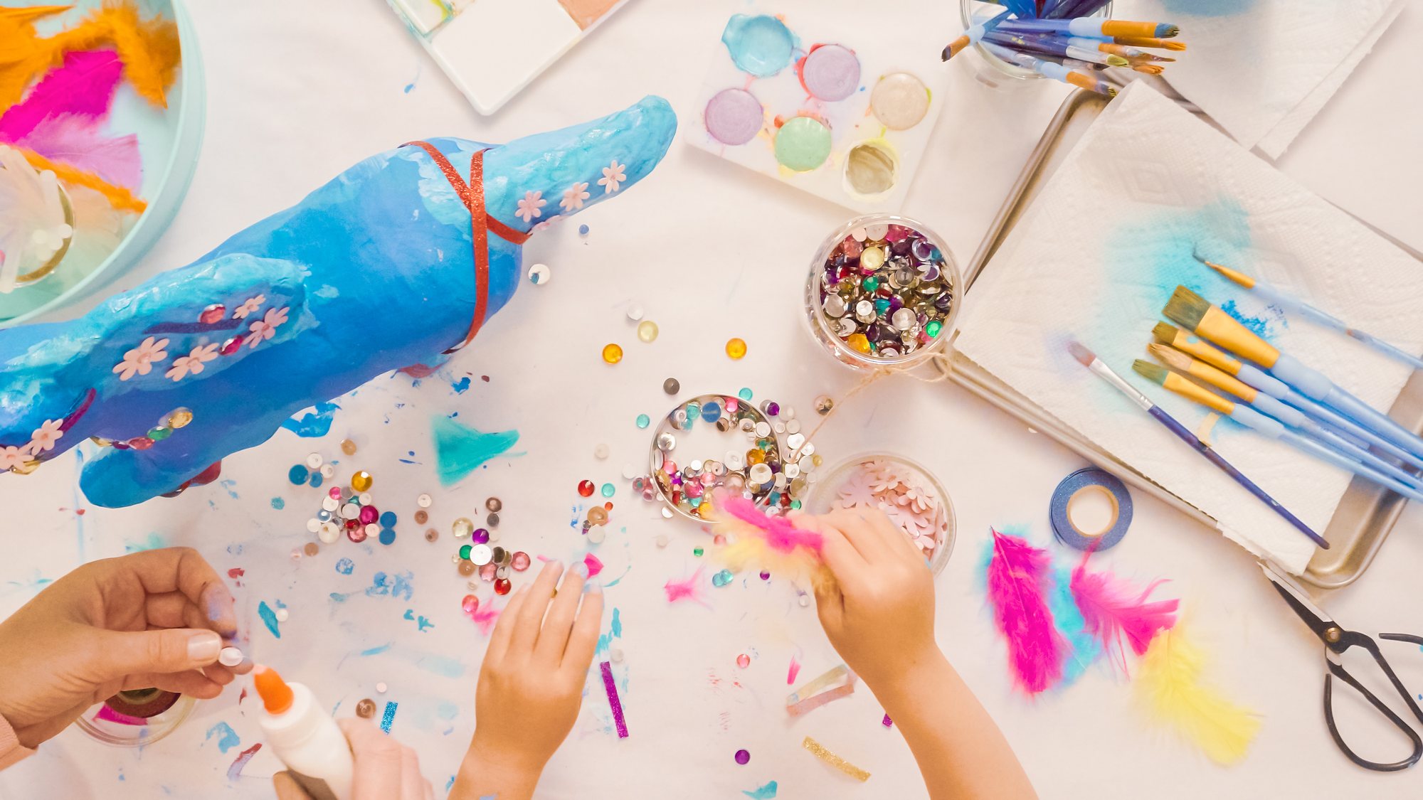 Kids decorating a paper mache sculpture