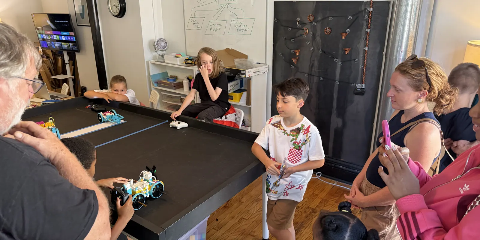 An instructor and campers running robots on the practice table